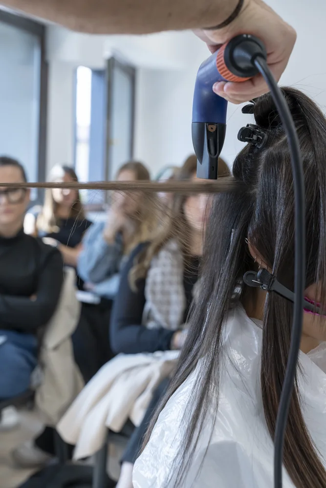 Educator blow-drying a model during an Adaró Academy class