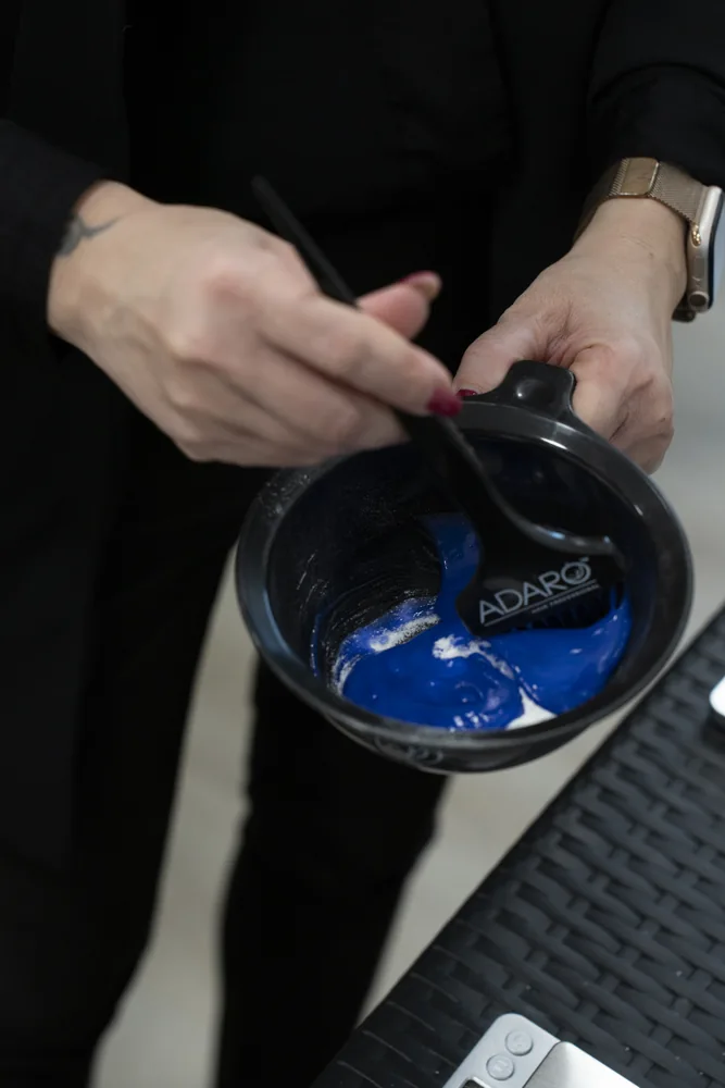 Stylist mixing lightener in an Adaró bowl